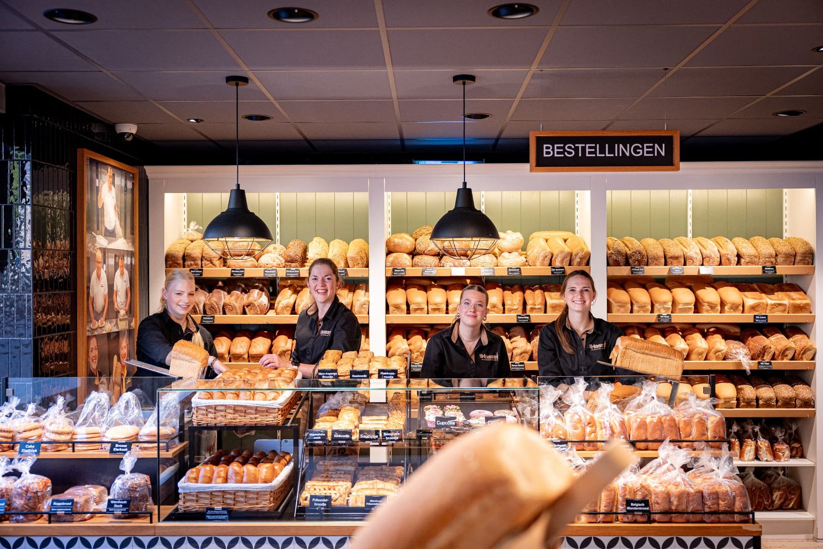 Winkelmedewerksters van Bakkerij van Hassel achter de toonbank in Wernhout